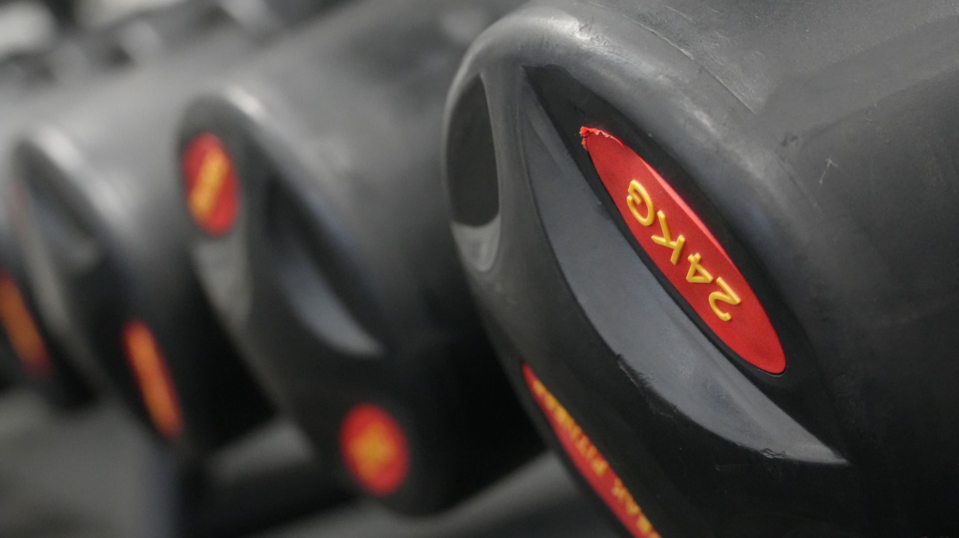 En person, der spiller gulvhockey på en grøn bane, holder en stav og en orange bold.