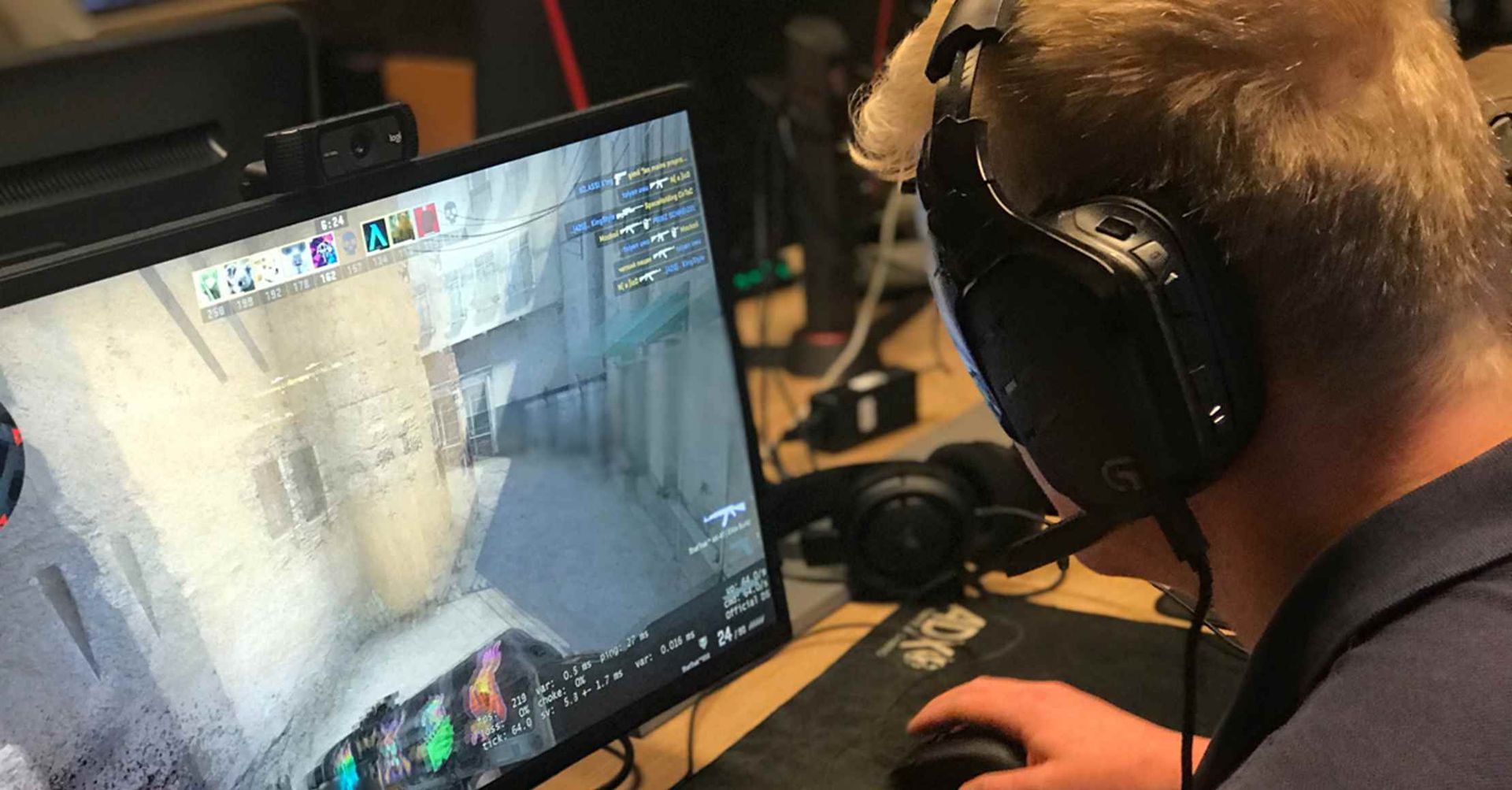 En person med headset spiller et videospil på en computerskærm.