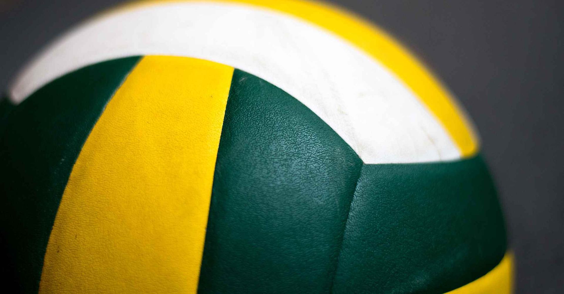 Grøn, gul og hvid volleyball, delvist i fokus.