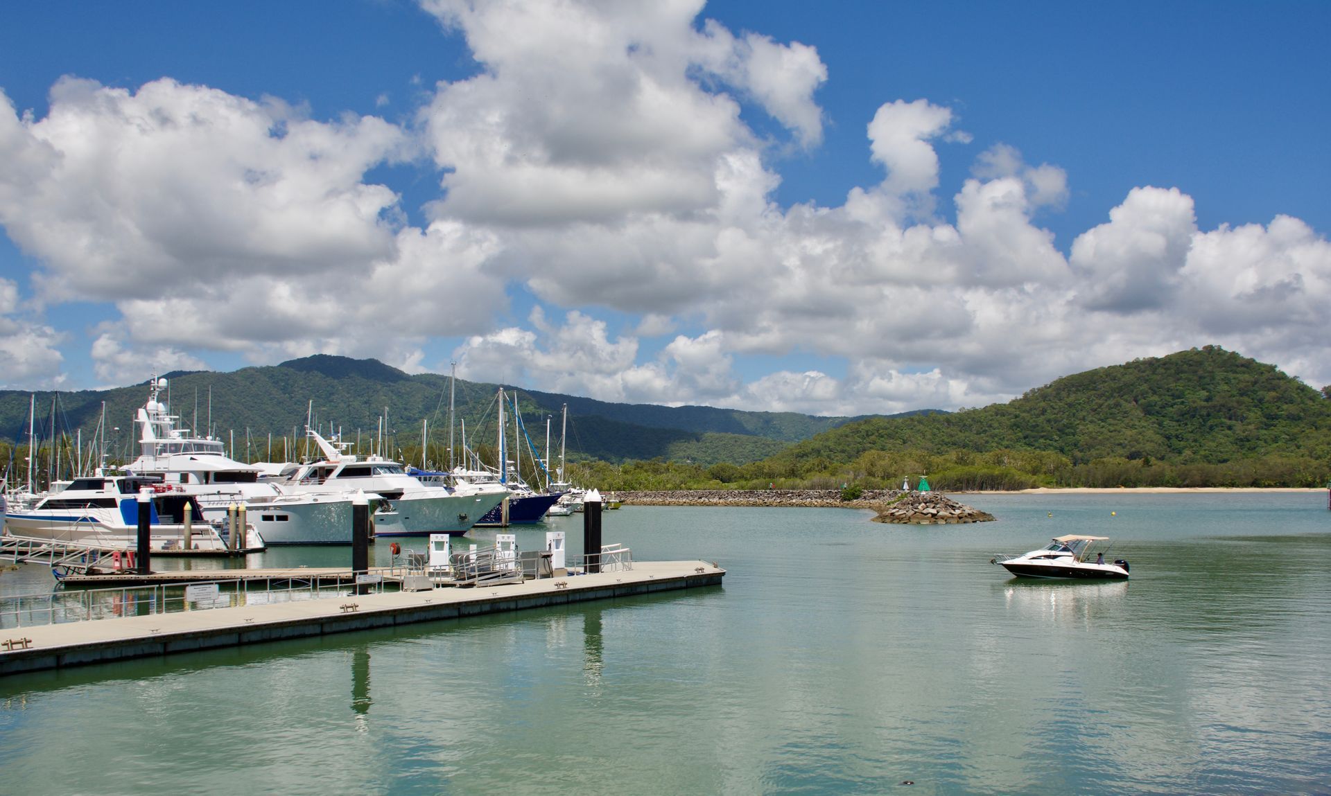 Boats Docked in Harbor With Lush Green Hills and a Bright Blue Sky With Clouds — Active Airconz in Cairns, QLD