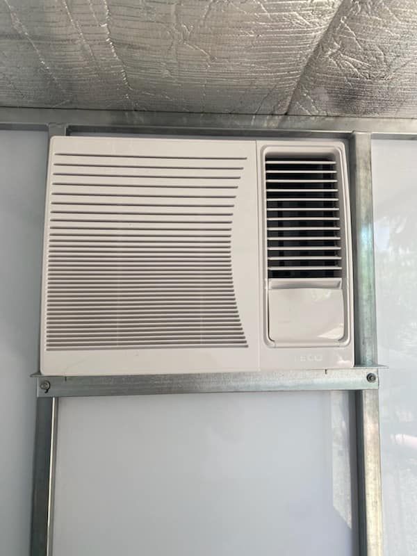White Air Conditioner Mounted on a Wall Inside a Metallic Frame — Active Airconz in Tennant Creek, NT