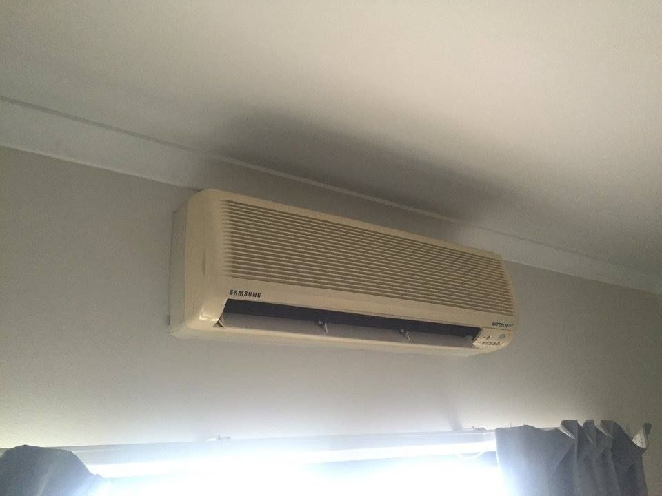 Off White Air Conditioner Mounted on a Light Gray Wall — Active Airconz in Brisbane, QLD