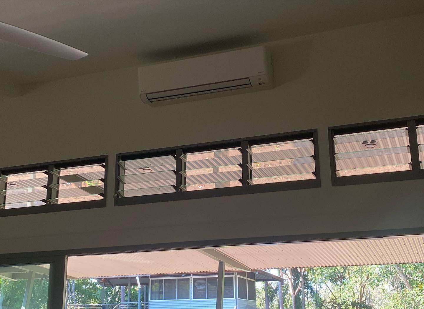 Air Conditioner Above Row of Glass Windows, Outdoors Visible Through the Windows — Active Airconz in Karumba, QLD