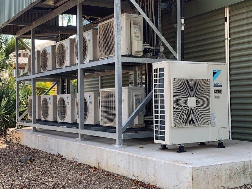 Outdoor air conditioning units on metal shelving next to a corrugated metal wall. — Active Airconz in Perth, WA