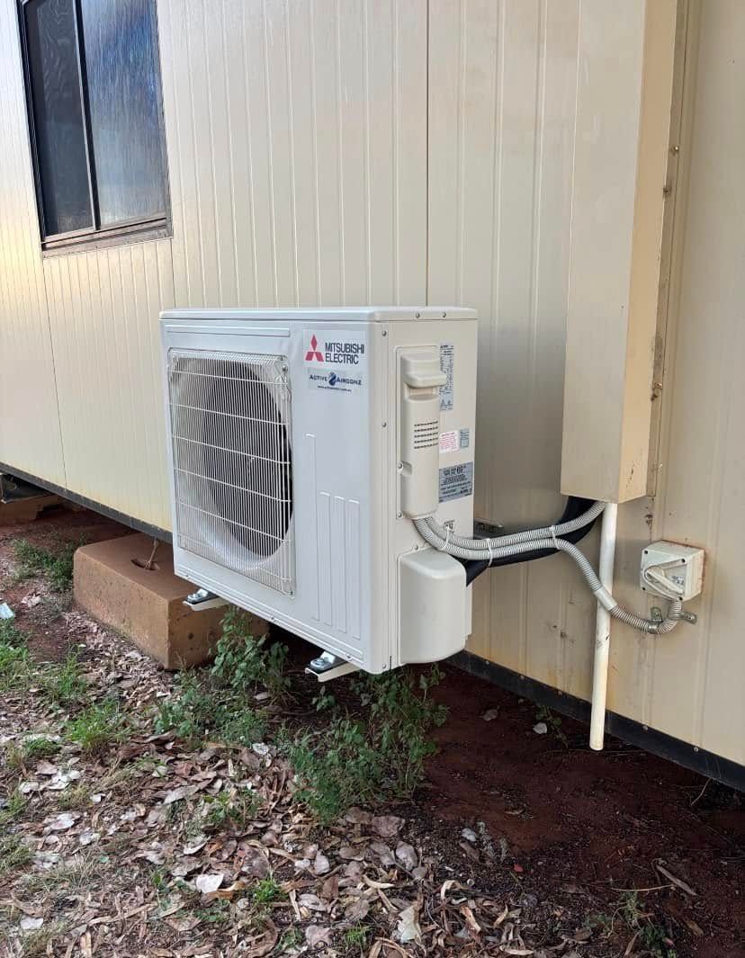 White Mitsubishi Air Conditioning Unit Mounted on a Tan Building Exterior — Active Airconz in Alice Springs, NT