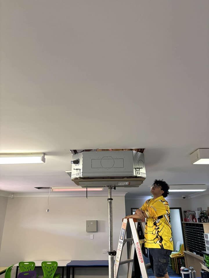 Person on a Ladder Installing Something Into a Ceiling — Active Airconz In Rockhampton, QLD