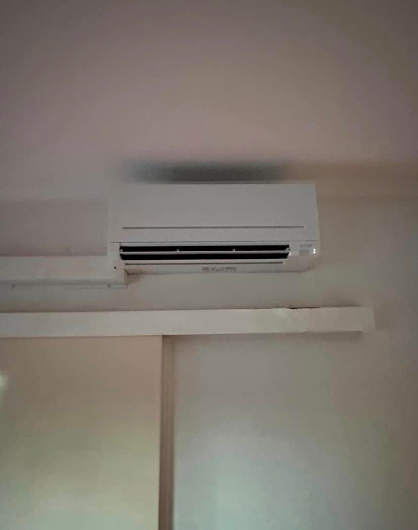 White Air Conditioning Unit Mounted on a White Wall, Above a White Panel — Active Airconz in Rural & Remote, NT