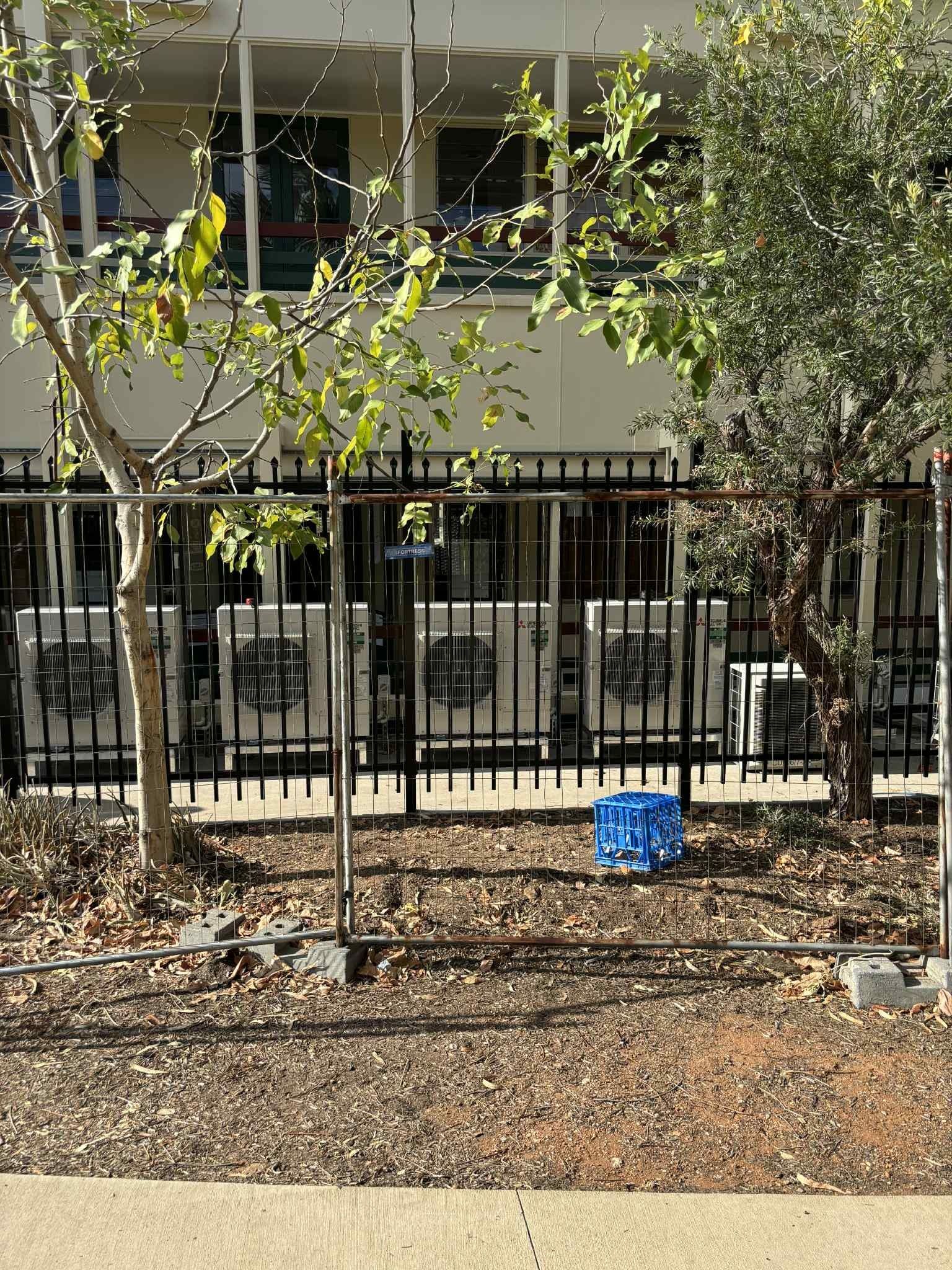Black Fence in Front of White Air Conditioning Units — Active Airconz in Sunshine Coast, QLD