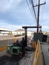 Una carretilla elevadora verde está cargando un contenedor en un camión.