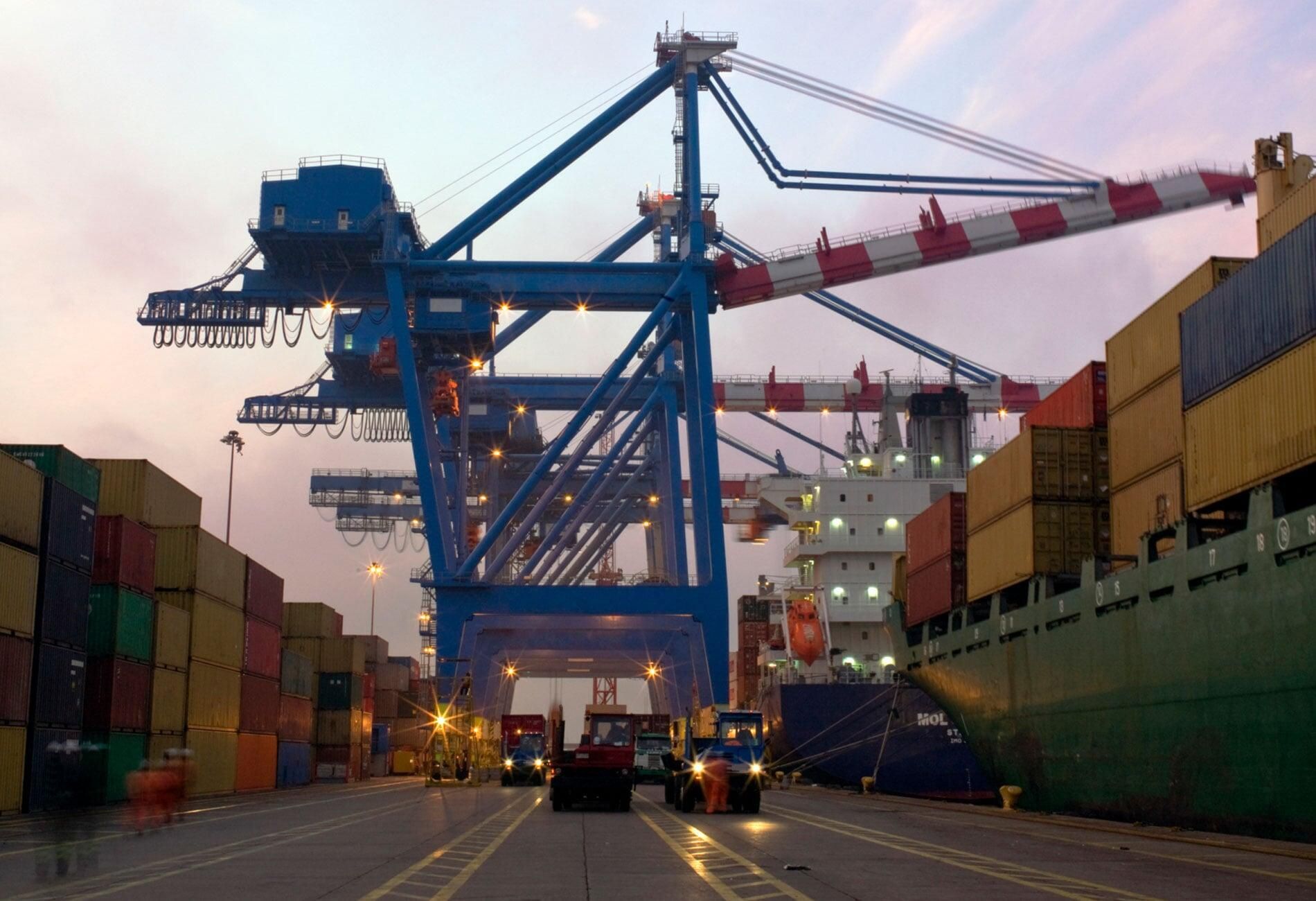 Un camión circula por una carretera delante de una gran grúa.
