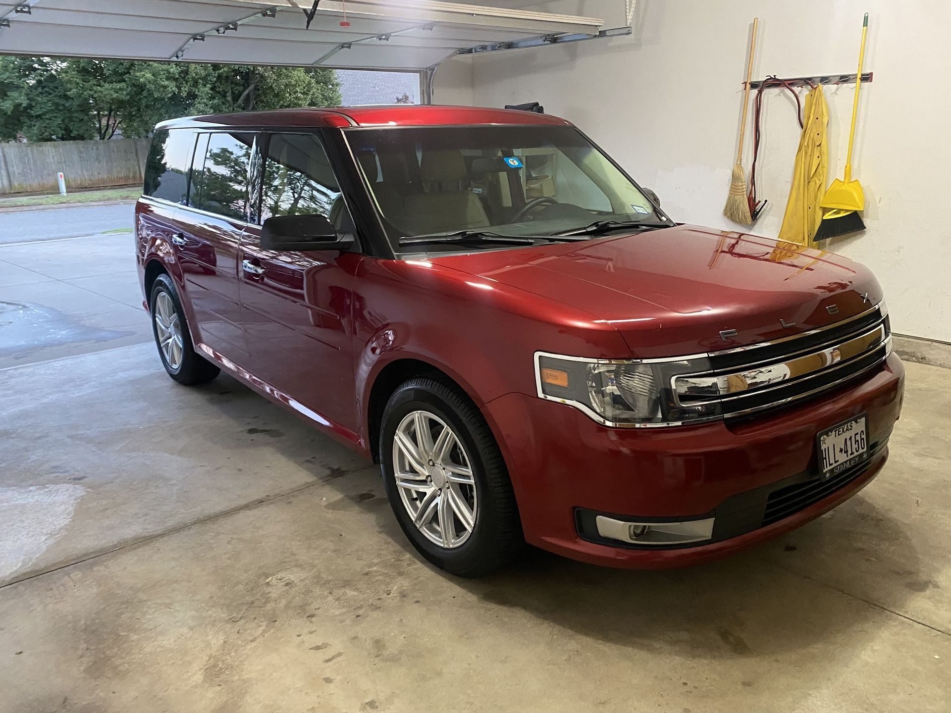 A red ford flex is parked in a garage bing washed
