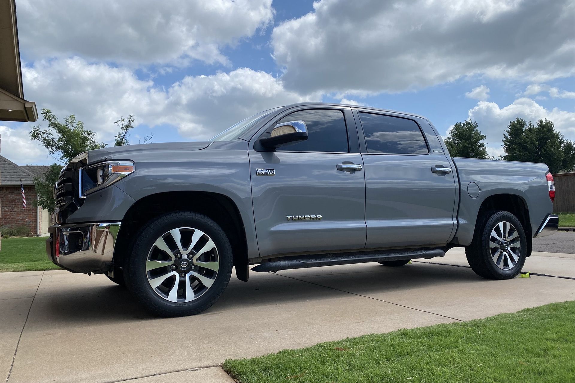A toyota tundra is parked in a driveway in front of a house being detailed