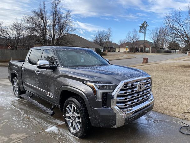 A toyota tundra is being washed in a driveway being washed