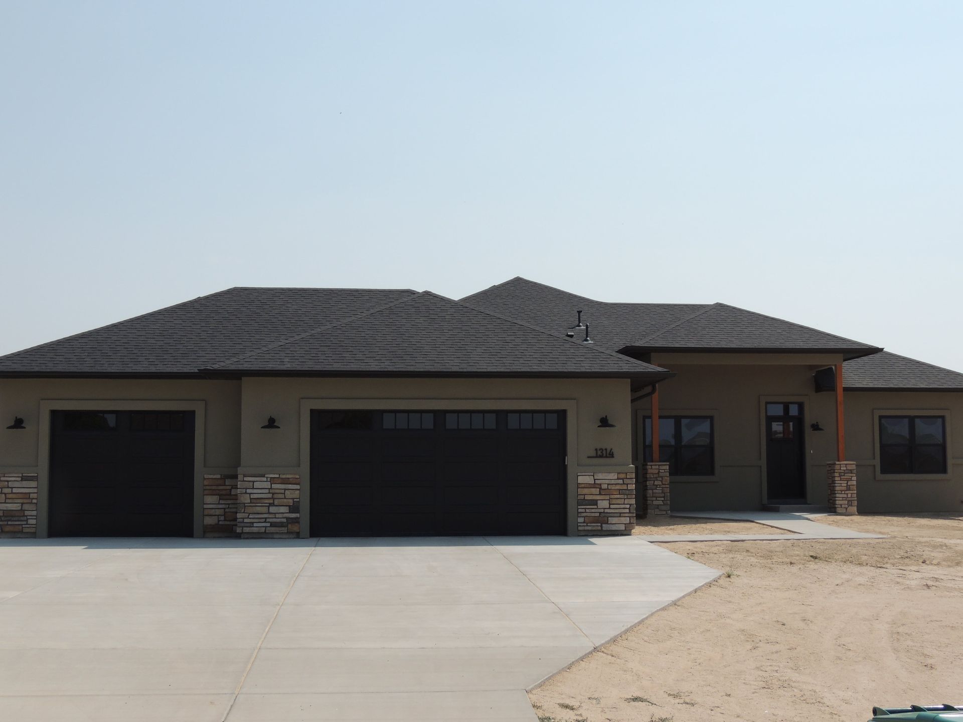 A house with three garage doors and a concrete driveway