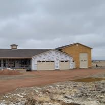 A house is being built in the middle of a dirt field.