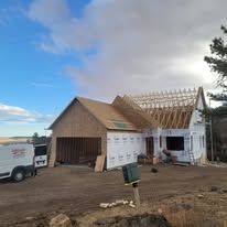 A white van is parked in front of a house under construction.