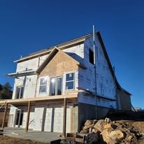 A large house is being built on a sunny day.