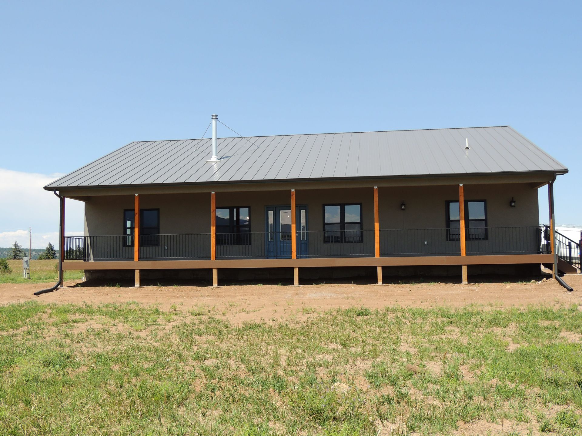 A large house with a large porch and a metal roof