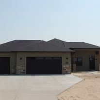 A large house with two garage doors and a driveway.