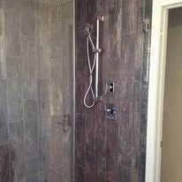 There is a shower with a glass door and a shower head.