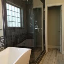 A bathroom with a tub , shower , and window.