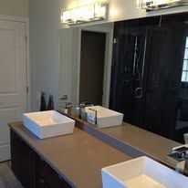 A bathroom with two sinks and a large mirror.