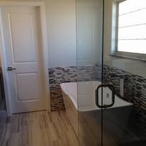 A bathroom with a tub and a shower with a glass door.