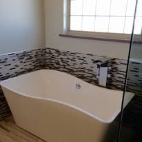A bathtub in a bathroom next to a window.