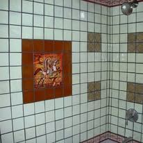 There is a picture of a horse on the wall in the shower.