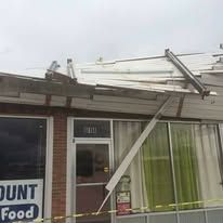 A building with a roof that has been damaged by a storm.