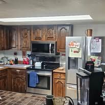 A kitchen with stainless steel appliances and wooden cabinets.