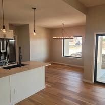 A kitchen with a sink , refrigerator , and sliding glass doors.