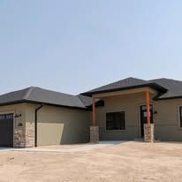A house with a garage and a porch on a sunny day.