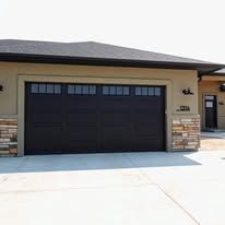A large black garage door is on the side of a house.