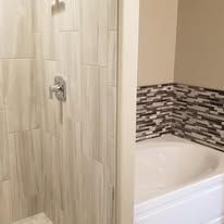 A bathroom with a shower and a bathtub.