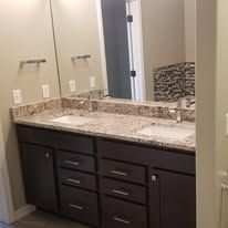 A bathroom with two sinks and a large mirror.