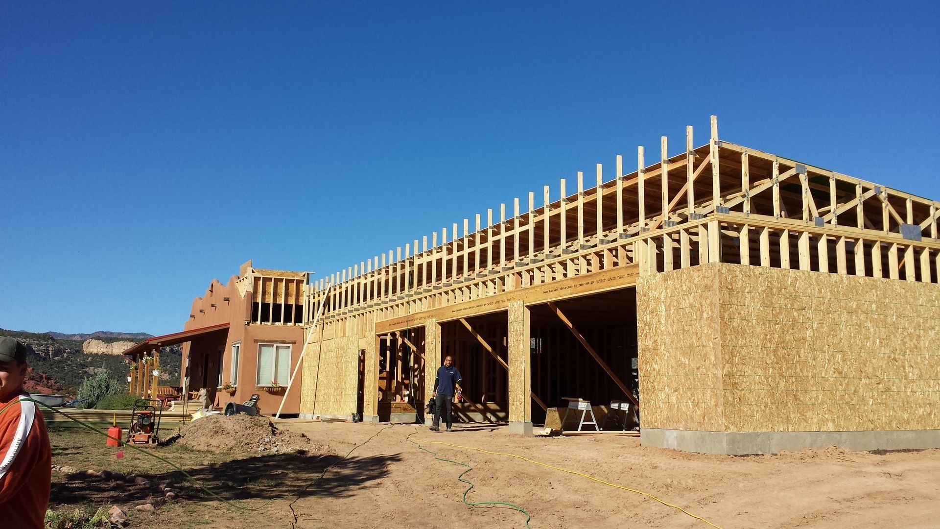 A large wooden building is being built in the desert