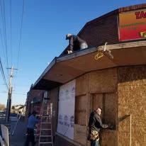 A man is working on the roof of a building.