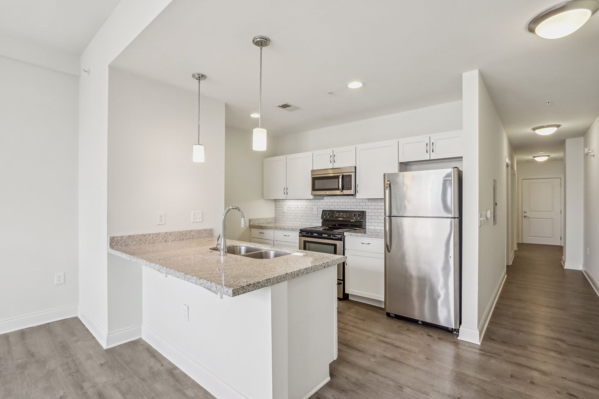 A kitchen with stainless steel appliances and white cabinets.