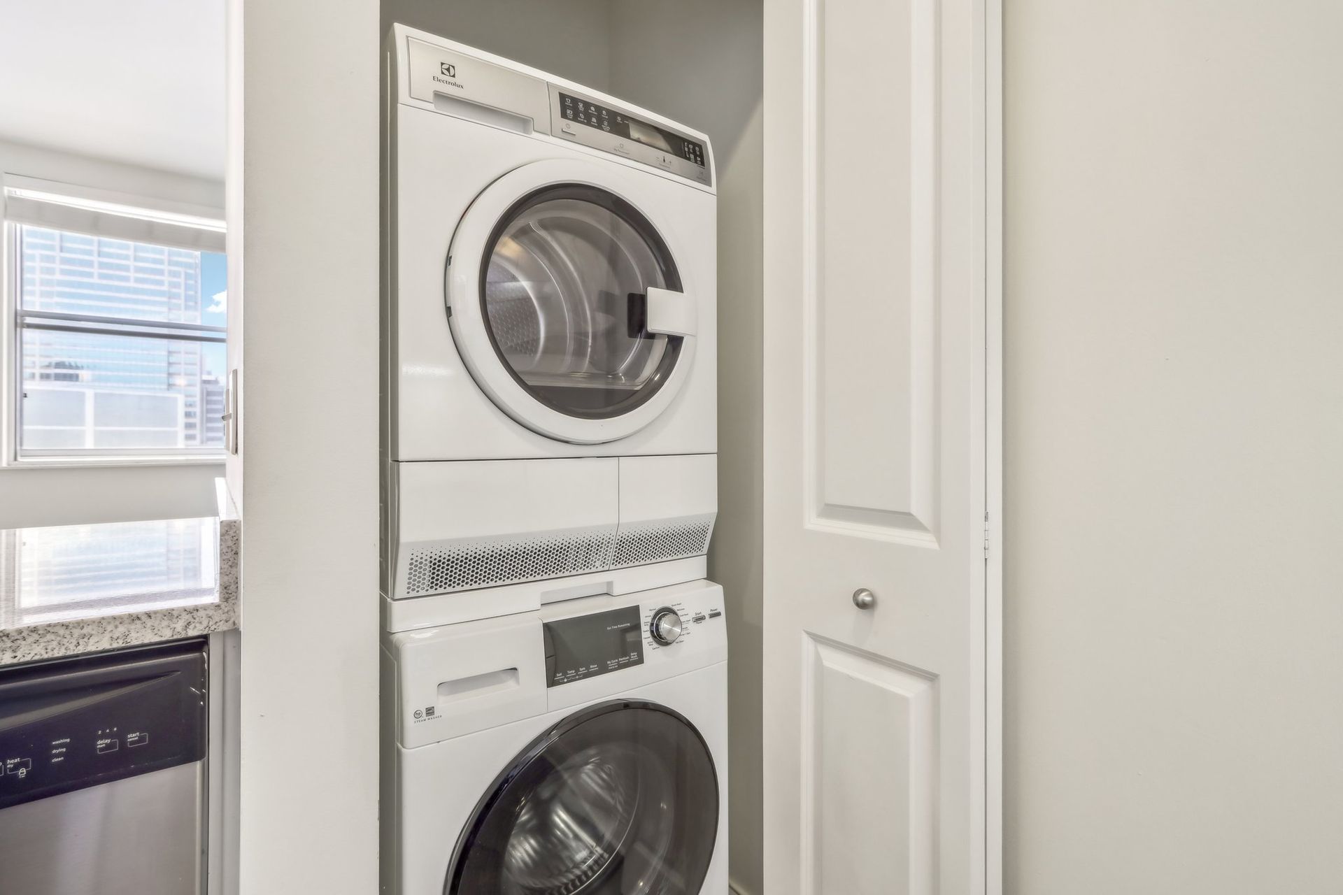 A washer and dryer are stacked on top of each other in a laundry room.