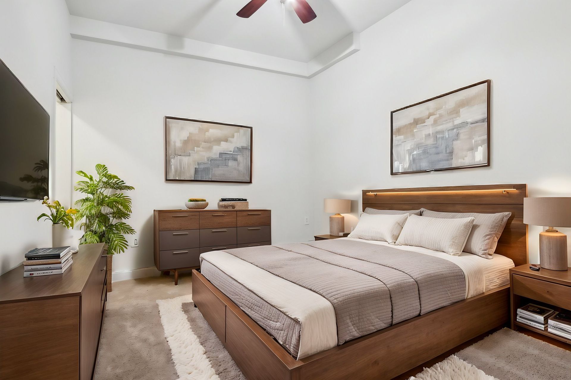 A bedroom with a large bed , dresser , nightstand and television.