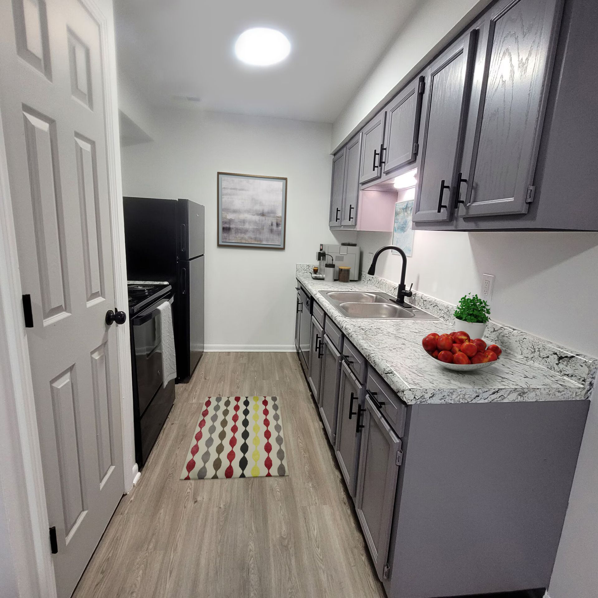 A kitchen with gray cabinets and granite counter tops