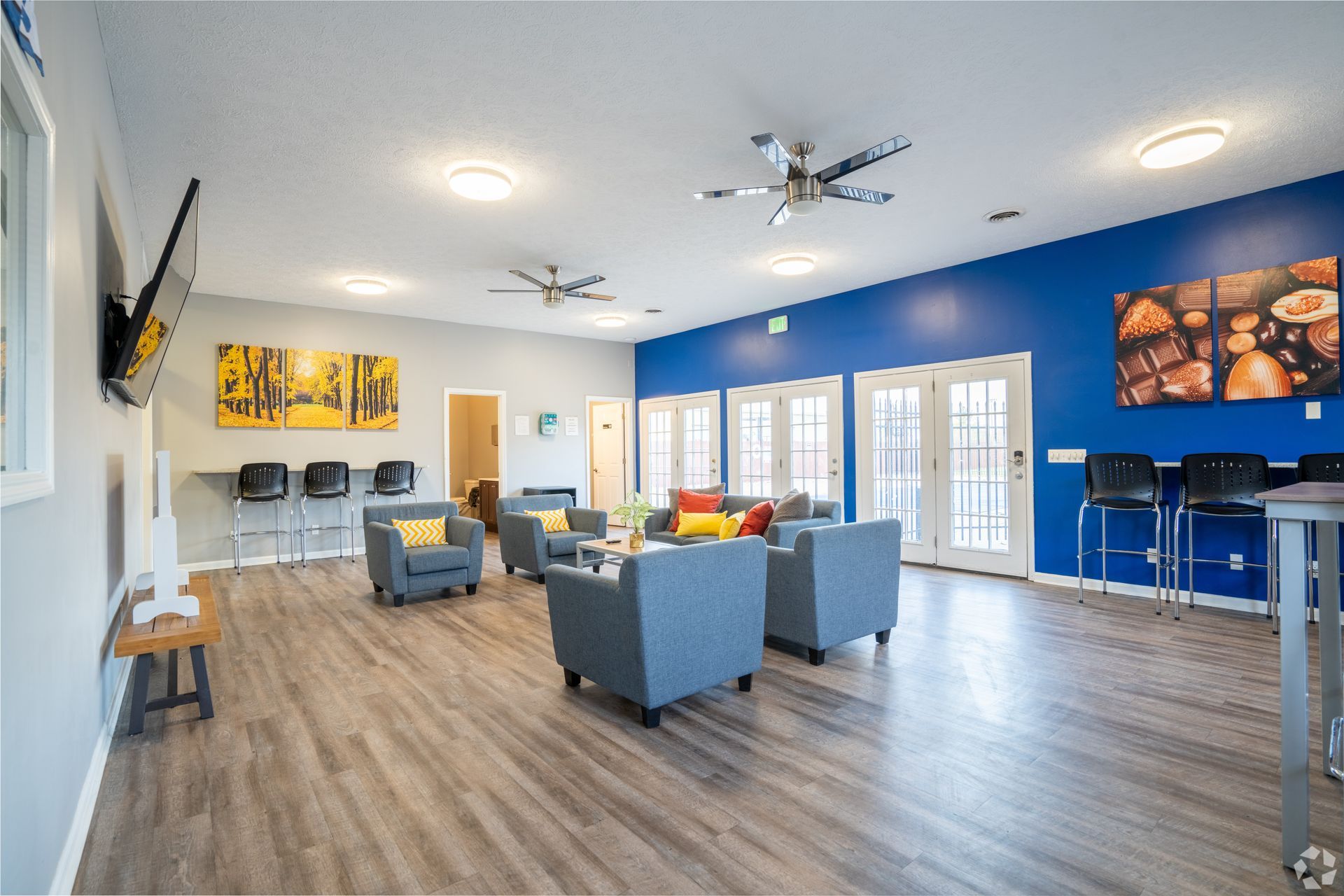 A large room with a lot of furniture and a television on the wall.