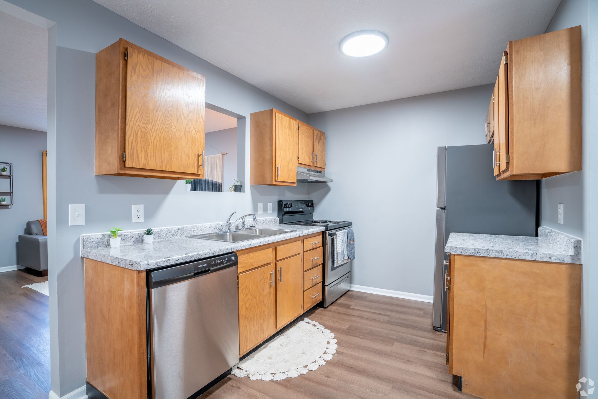 A kitchen with stainless steel appliances and wooden cabinets.