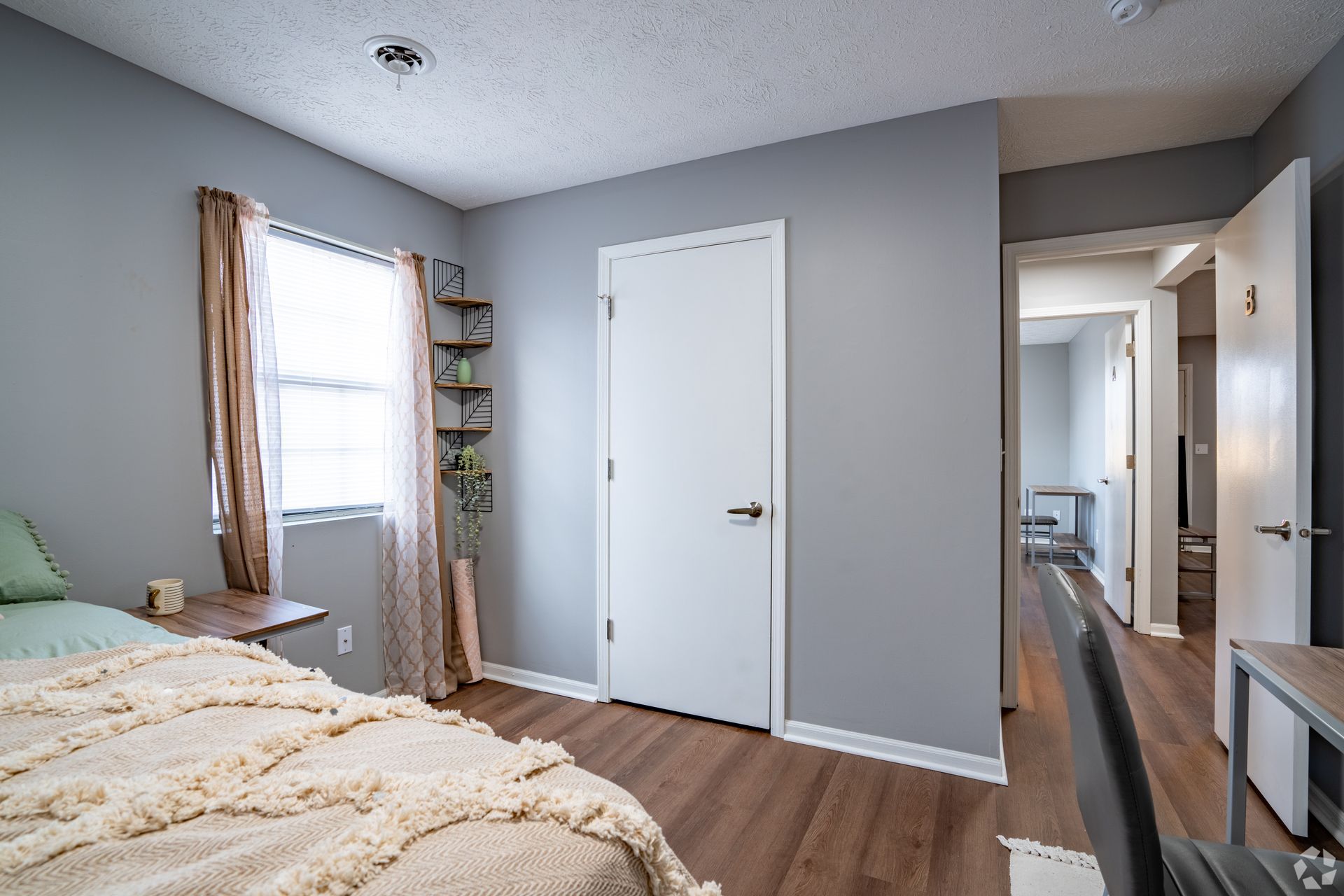 A bedroom with a bed , a window and a door.
