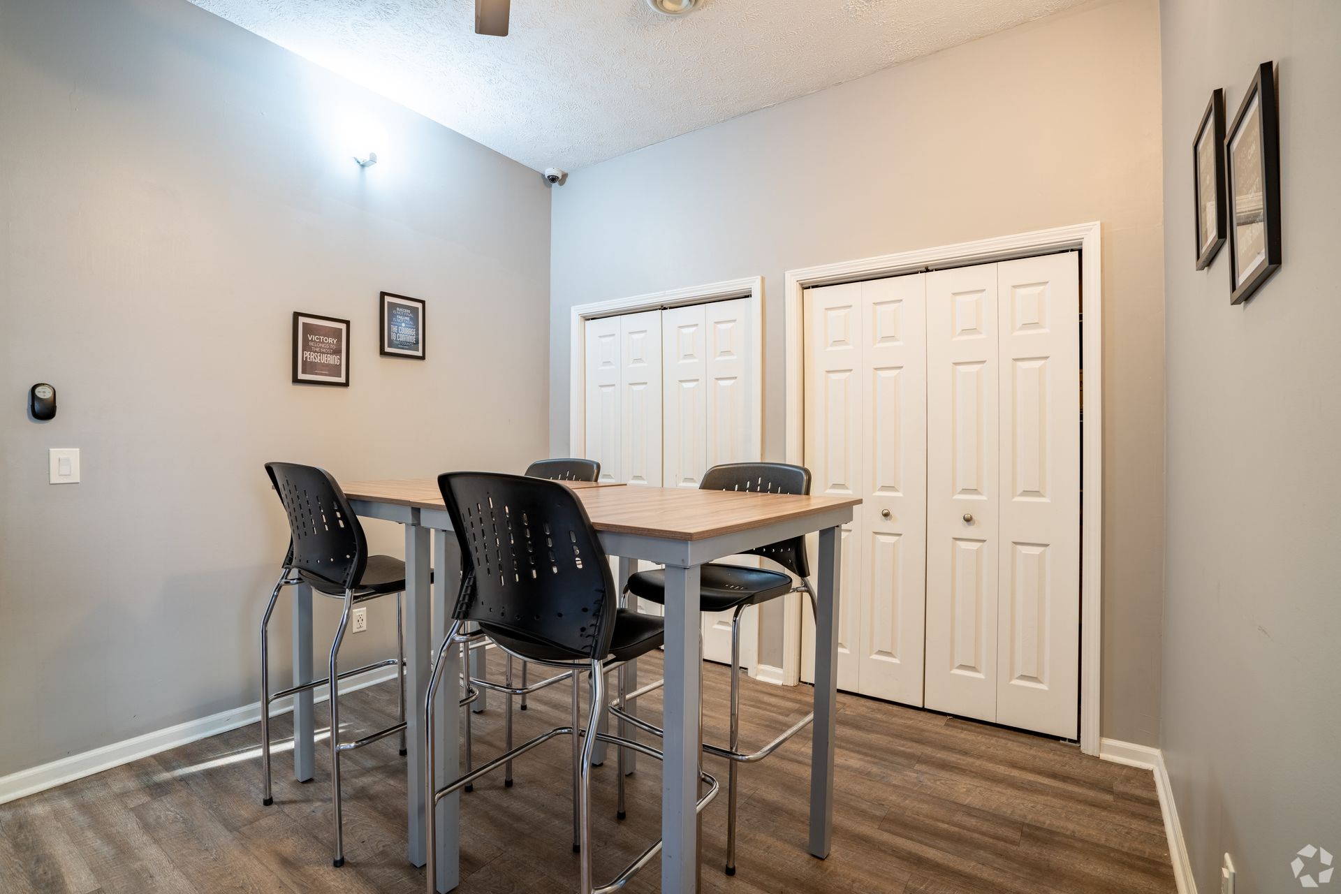 A dining room with a table and chairs and a ceiling fan.