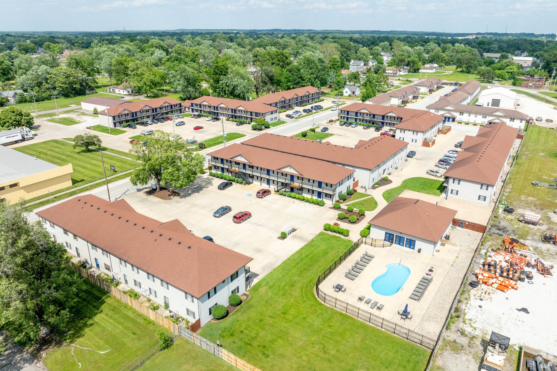 An aerial view of a large apartment complex with a pool in the middle.