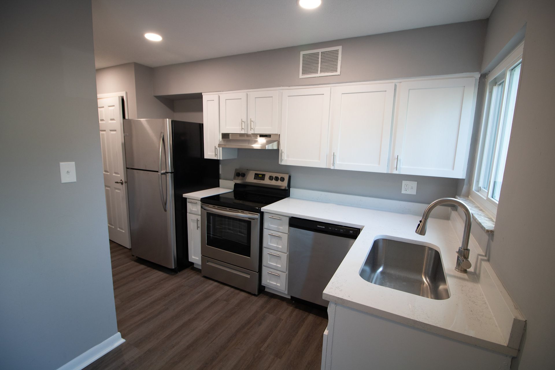 A kitchen with stainless steel appliances and white cabinets