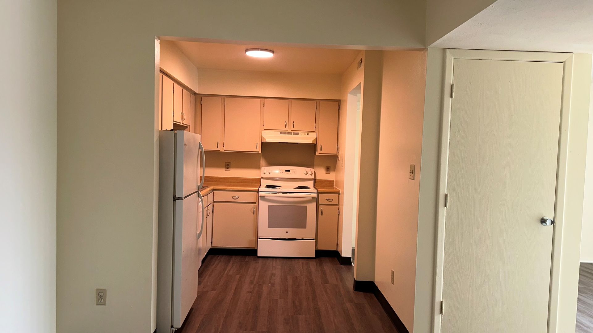 A kitchen with a stove , refrigerator , and cabinets.