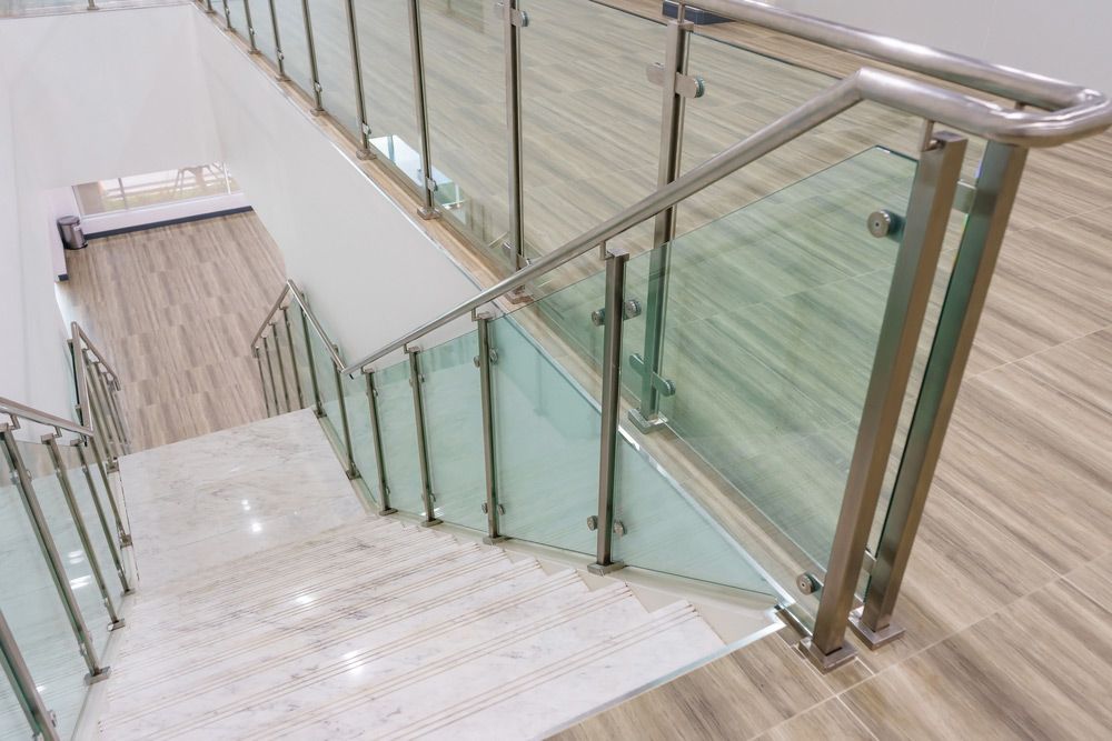A Staircase With A Stainless Steel Railing And A Glass Railing — Universal Marble & Granite In Grafton, NSW